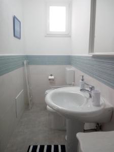 a white bathroom with a sink and a window at B&b la finestra sul mare in Capo dʼOrlando +13 photos