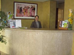 a woman standing behind a counter in a room at Hotel Dom Vilas in Braga