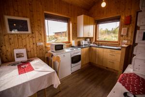 a small kitchen with a table and a stove at Hestasport Cottages in Varmahlid
