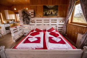 a bedroom with a large bed with red pillows at Hestasport Cottages in Varmahlid +37 photos