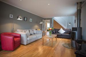 sala de estar con sofá blanco y silla roja en Warwick Lodge en Perranporth