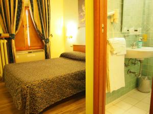 a small bedroom with a bed and a sink at Hotel Santa Croce in Florence