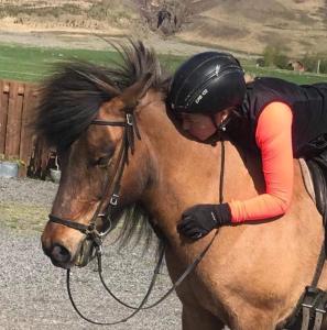 une femme à cheval sur le dos d'un cheval dans l'établissement Flugumýri 2, à Varmahlid