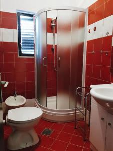 een badkamer met een douche, een toilet en een wastafel bij Apartments Grahovac in Umag