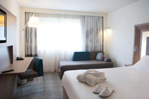 
A bed or beds in a room at Novotel Fontainebleau Ury
