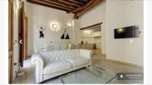 sala de estar con sofá blanco y TV en Torres de Valencia Apartments, en Valencia