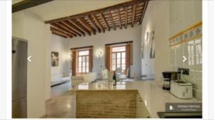 a large kitchen with white walls and wooden ceilings at Torres de Valencia Apartments in Valencia