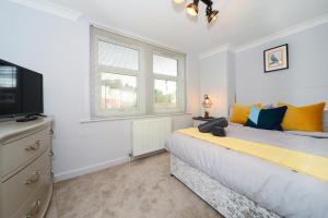 a bedroom with a bed and a tv and a window at Beautiful Apartment near Bournemouth, Poole & Sandbanks in Poole