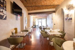 a restaurant with tables and chairs and a television at Palazzo Centro Alloggi Vacanza in Nizza Monferrato