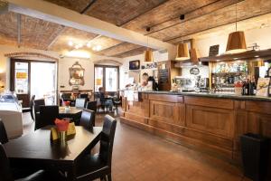 a restaurant with a bar with tables and chairs at Palazzo Centro Alloggi Vacanza in Nizza Monferrato
