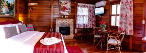 a bedroom with a bed and a fireplace at Chez Domaine Pousada Organica in Pedra Azul