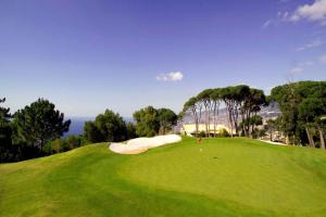 a putting green with a bunker on the side at Designed Villa Palheiro Village by Holiday Rental Madeira in Funchal