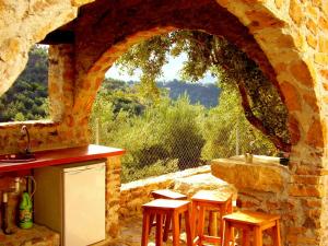 a stone kitchen with a counter and a window at Alojamiento rural El Agüelo in Huelma