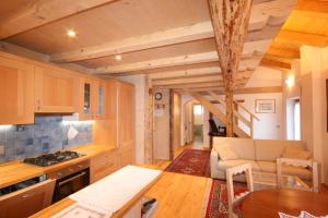 a kitchen and living room in a log cabin at Casa Sottsass in Falcade