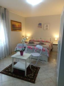 a bedroom with a bed and a table and chairs at B&b la finestra sul mare in Capo dʼOrlando