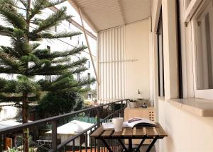 a balcony with a table with books and a tree at São Miguel 50 in Porto