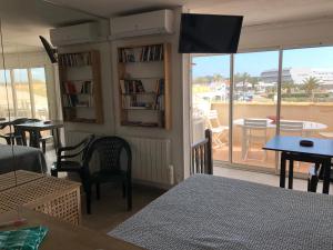 a living room with a tv on the wall and a balcony at Naturiste Port Soleil avec piscine in Cap d'Agde