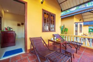 a porch with chairs and a table on a balcony at Sea Star Resort in Phú Quốc
