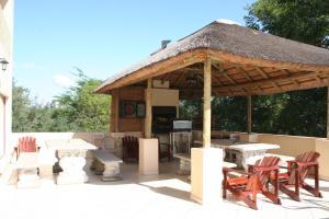 un padiglione con sedie, tavoli e tetto di paglia di Villa Royal Palm a Komatipoort