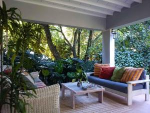 a patio with a blue couch and a table at Africa's Eden Guesthouse in Pietermaritzburg