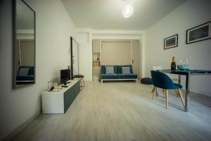- un salon avec une télévision et un canapé bleu dans l'établissement Clever House, à Milan