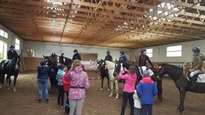 a group of people riding horses in a building at Stajnia Grazyny Mikorowo 46 in Czarna Dąbrówka