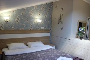 a bedroom with a bed and a wall with flowers at Provance Guest House in Tsemdolina