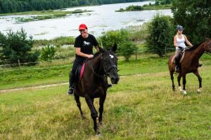 a man and a woman riding horses in a field at Stajnia Grazyny Mikorowo 46 in Czarna Dąbrówka +7 photos