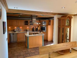 a large kitchen with wooden cabinets and a bench at Haus am Kienberg in Schwangau