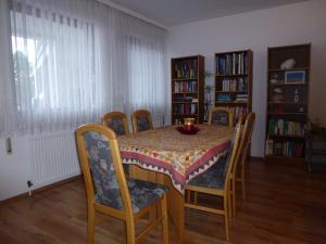 a dining room with a table and chairs and bookshelves at Appartment Cerny in Eisenstadt