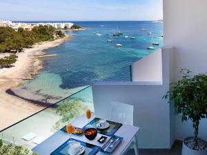 
a beach scene with a view of the ocean at AxelBeach Ibiza Suites Apartments Spa and Beach Club - Adults Only in San Antonio Bay
