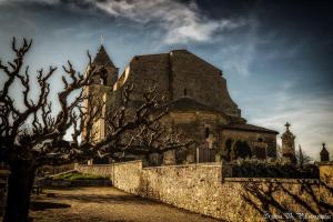 an old church behind a stone wall with trees at Suite Provençale in Saignon