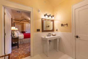 a bathroom with a sink and a bedroom at Steele Mansion Inn & Gathering Hub in Painesville