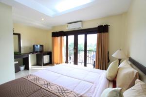 a bedroom with a large bed and a balcony at Coco Nori @ Sea Resort in Klong Muang Beach