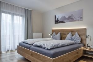 a bedroom with a large bed with a wooden headboard at HILLSIDE Apartments Pircher in Fügen