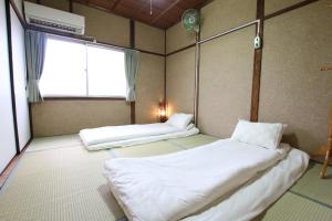 a room with two beds and a window at 2 floors japanese style, direct to KIX, 10mins train to Namba, 5mins walk to stn , 2-6ppl in Osaka