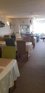 a dining room with white tables and chairs and a unintention at Shipping Lanes Hotel in Morecambe