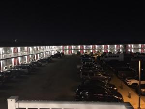Red Deer Inn & Suites في ريد دير: موقف سيارات فيه سيارات متوقفة في الليل