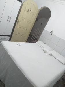 Una mesa blanca en una habitación con puerta en Hotel Raiz, en Manaus