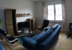 a living room with a blue couch and chairs at Ferienwohnung Wanderurlaub Thüringen in Schmalkalden