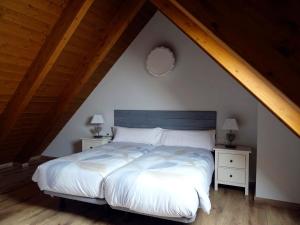 een slaapkamer met een wit bed en 2 nachtkastjes bij Apartamento Bachimala in Huesca