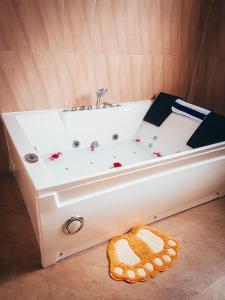 Una bañera blanca situada en la esquina de un baño. en Amber House Lanka, en Bentota