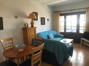 a living room with a blue couch and a table at Apartamento Salinas del Mar in Orzola +14 photos