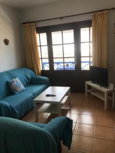Apartamento Salinas del Mar في أورزولا: غرفة معيشة مع أريكة وطاولة