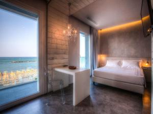 Schlafzimmer mit einem Bett und Meerblick in der Unterkunft Bell Suite Hotel in Bellaria-Igea Marina