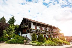 a building with a balcony and bushes in front of it at Ferienwohnanlage Prinzenhof in Sankt Andreasberg