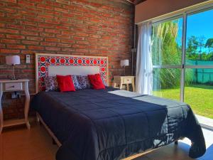 ein Schlafzimmer mit einem großen Bett mit Ziegelwand in der Unterkunft Cabañas Bruma in Monte Hermoso