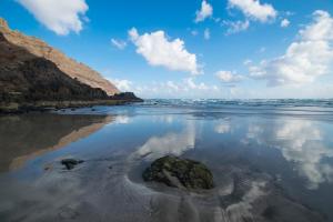 a rock in the sand on a beach at Apartamento Salinas del Mar in Orzola