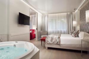 フィレンツェにあるポンテ ヴェッキオ スイーツ & スパのベッドとバスタブ付きのホテルルームです。