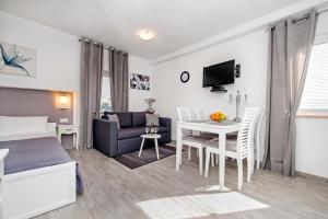 een slaapkamer en een woonkamer met een bed en een tafel bij Studio Apartment Sunce in Rovinj